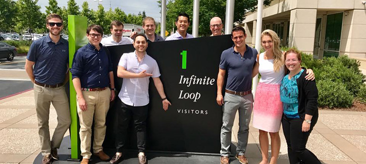 Students posing in front of Apple Computer sign